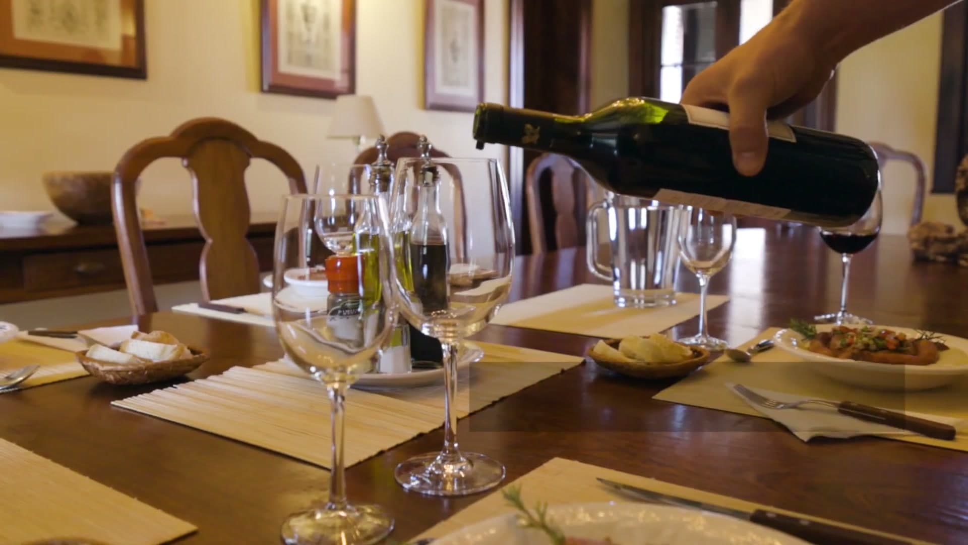 Red wine being poured into a glass at the lodge dining table